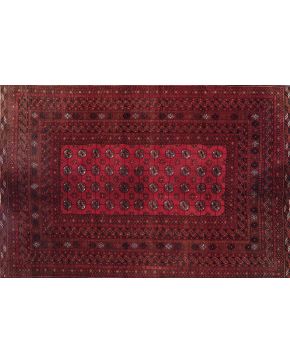 854-Alfombra en lana Tukoman con decoración de motivos geométricos sobre fondo granate.