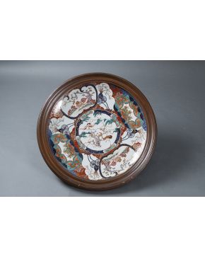 481-Gran plato en porcelana oriental. siguiendo los modelos Imari. s. XIX. Profusa decoración de motivos vegetales. animales y de aves.