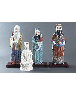 462-Lote de cuatro figuras en porcelana china esmaltada. tres sabios ancianos representando a Shou. Lu y Fu. sobre peanas en madera y Buda en porcelana b
