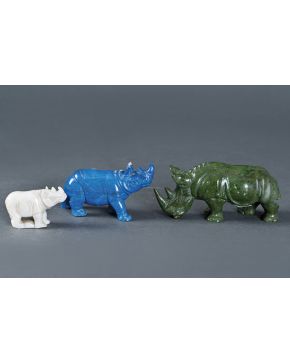 1052-Lote de tres figuras de rinocerontes en tamaños decrecientes en jade. lapislázuli y cuarzo opalescente. Una de ellas consolidada.