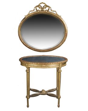 992-Lote formado por mesita oval y espejo oval en madera tallada y dorada estilo Luis XVI. s. XIX. Mesita auxiliar con tapa de cristal y patas acanaladas 