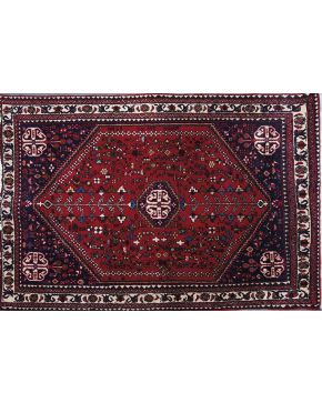940-Alformbra persa en lana Abadeh con decoración vegetal y floral sobre campo granate.