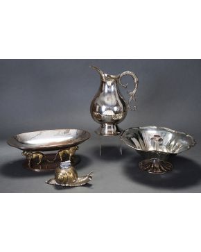 825-Decorativo lote en metal plateado y dorado formado por mechero en forma de caracol y centro de mesa oval con soporte en forma de pareja de leones. 