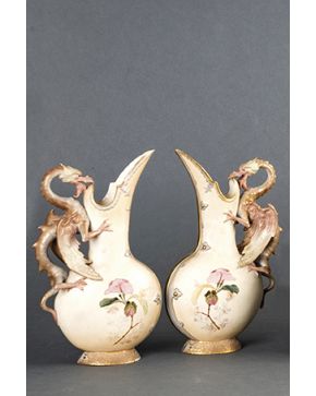 1050-Pareja de jarras modernistas en porcelana austriaca con marcas de Robert Hanke. C. 1910.  Asas con forma de dragón imaginario y decoración de lfores.