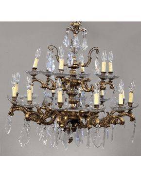 1003-Lámpara de techo de 18 luces en bronce dorado y cristal tallado. Brazos con forma de tornapuntas con decoracion de pandelocas. platillos y esfera colg