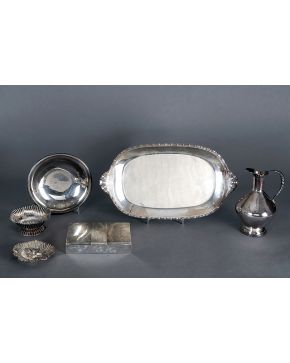 1233-Sencilla jarra en plata española punzonada. Cuerpo liso con motivo sogueado en asa y base. Altura: 24.5 cm. 