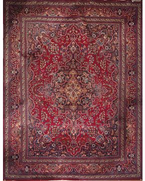 968-Alfombra persa en lana con decoración geométrica y vegetal sobre campo granate.