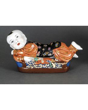 870-Almohada china en porcelana esmalta con motivo de niño recostado. Con marcas en la base. 