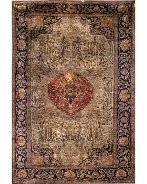 840-Antigua alfombra persa en lana y seda con decoración vegetal y centro polilobulado en tono granate. Sobre campo verde y cenefa perimetral con decoraci