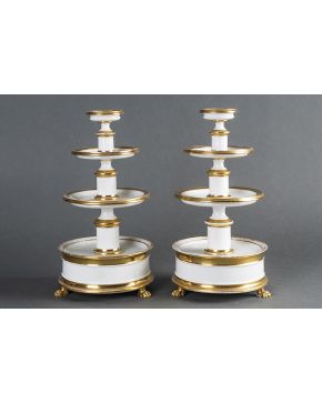 1119-Elegante pareja de portadulces en porcelana centroeuropea esmaltada en blanco con filos en dorado. Diferentes alturas. Sobre patitas de garra. 