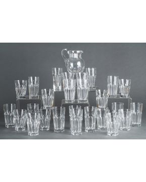 1108-Lote en cristal de Baccarat formado por 14 vasos altos. 12 vasos más pequeños y jarrita de agua. Decoración facetada. Algún leve piquete. Con sello e 