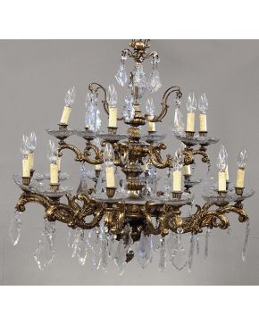 943-Lámpara de techo de 18 luces en bronce dorado y cristal tallado. Brazos con forma de tornapuntas con decoración de pandelocas. platillos y esfera colg