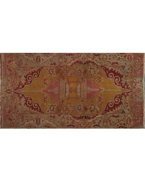 892-Antigua alfombra oriental con motivo arquitectónico central sobre campo color mostaza y cenefa con motivos geométricos sobre campo verde agua. Colores