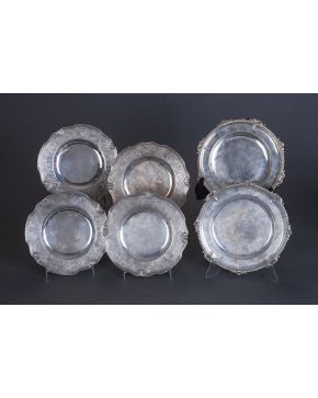697-Juego de cuatro platos en plata de ley 950 con alero grabado con tornapuntas. ces. motivos vegetales y de retícula. Perfil decorado con conchas. Con