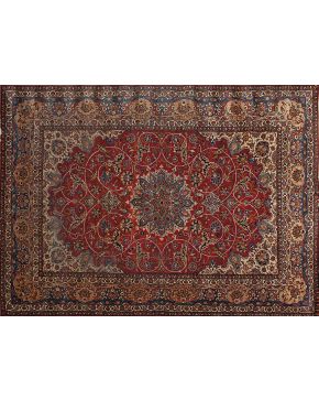 822-Gran alfombra persa Mashad en lana con diseño vegetal sobre campo granate. Centro con rosetón polilobulado sobre campo azul. Colores complementarios: 