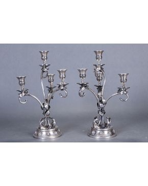 615-Elegante pareja de candelabros de cuatro luces en plata española punzonada con aplicaciones de flores y brazos a modo de ramas. Sobre pie circular.