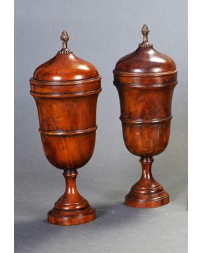 616-Pareja de urnas con tapa en madera de caoba. Inglaterra. s. XIX.  Remate de piña en bronce dorado. 