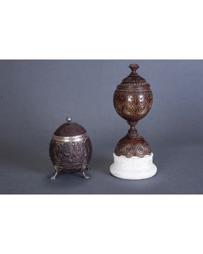 651-Pareja de cocos tallados. Uno de ellos con peana de mármol. profusa decoración y ligeras faltas. El otro con montura en plata inglesa con marcas de Lo
