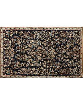 789-Alfombra persa en lana y seda con profusa decoración de jarrones con flores y elementos vegetales sobre campo azul oscuro. 