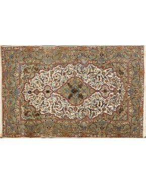 780-Alfombra persa en seda y lana con decoración lobulada central y profusa decoración vegetal sobre campo verde y centro en beige.