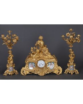 859-Reloj con guarnición de candelabros en bronce dorado y placas de porcelana de Sevres. Francia. s. XIX.