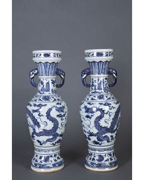 421-Pareja de estilizados jarrones en porcelana china blanca y azul con asas en forma de cabezas de elefante . animales fantásticos y elementos florales y
