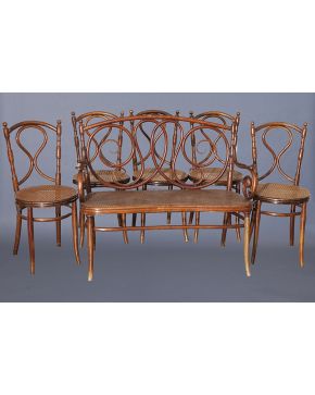 970-Conjunto formado por 5 sillas. un banquito en madera tallada con asiento de rejilla y perchero. Marcas en la silla de Jacob Joseph Kohn. Viena. s. XIX