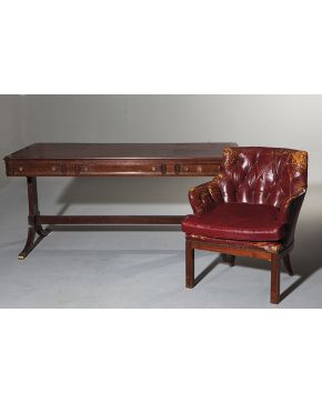 561-Lote formado por: Mesa escritorio. s. XIX con cajones en cintura y tapete en cuero marrón; y butaca en cuero rojo capitoné (con desperfectos). 