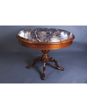 733-Mesa circular en madera tallada con tapa de mármol negro veteado. Sobre pata de jarrón. S. XIX.