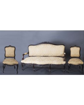 1027-Sillería isabelina. s. XIX. Compuesta por sofá y seis sillas en madera de caoba tallada con copete de flores. Tapicería en damasco. Patas de rueda.
