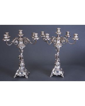 678-Gran pareja de candelabros de cinco luces convertibles en candeleros en plata. Original fuste a modo de angelitos sobre animal marino. uno de ellos su