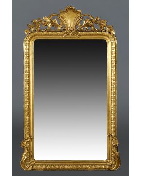 769-Espejo en madera tallada y dorada. Ovas en perímetro y gran copete laureado.