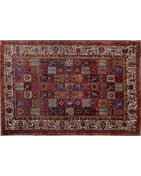 789-Antigua alfombra persa en lana con decoración vegetal. floral y motivos estilizados con centro en retícula y cenefa en beige con profusa decoración.