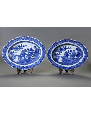 441-Lote formado por dos fuentes ovales en porcelana china. s. XIX. Con decoración estampada en azul sobre blanco. Motivos arquitectónicos en el campo. 