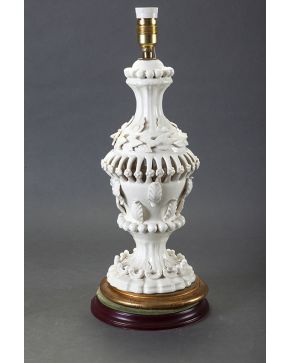 492-Lámpara de sobremesa en porcelana con fuste a modo de jarrón calado con decoración de hojas y flores y tornapuntas. Sobre base en madera tallada y dor