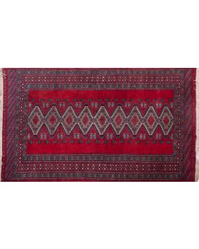 369-Alfombra persa en lana con decoración geométrica y cenefa sobre campo granate. 