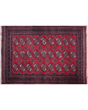 384-Alfombra persa en lana con decoración geométrica y medallón central sobre campo granate.