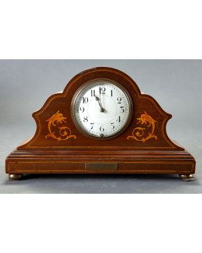 458-Reloj de sobremesa con caja en madera tallada y decoración de marqueteria. Con marcas: Kirkdale brunch L.W.C.A. 1913.