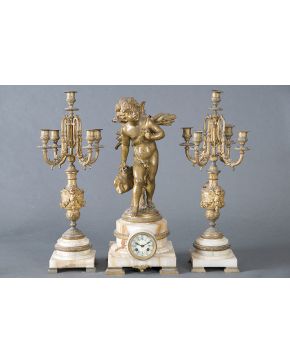 728-Reloj francés con guarnición de candelabros de 5 luces en mármol rosa y bronce dorado. c.1920. Esfera en porcelana blanca con numeración romana en azu