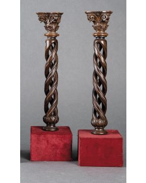 1180-Pareja de columnas portuguesas helicoidales en madera de palosanto con fileteado en hueso y capitel corintio. Sobre peanas cuadradas en terciopelo roj