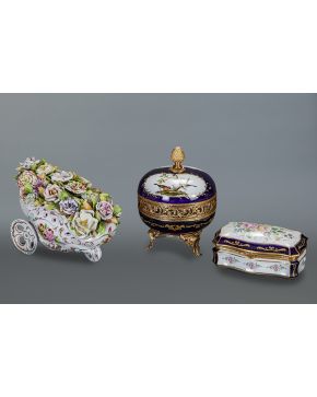 589-Delicada carretilla cargada de flores en porcelana esmaltada. dorada y policromada. Con marcas.