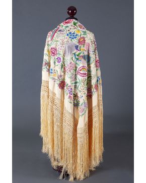 867-Mantón de Manila s. XX. De seda en color vainilla bordado en vivos colores con flores. pavos reales y aves del paraíso.