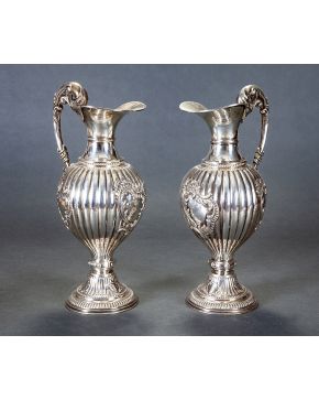 837-Elegante pareja de jarras en plata española punzonada. Cuerpo gallonado con rocallas formando reservas y asas en forma de tornapuntas.