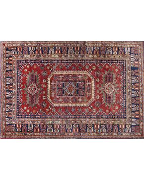 926-Alfombra persa en lana. Diseño esquemático sobre campo rojo.
