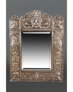 1063-Espejo en plata y alma de madera con decoración en relieve. España. c. 1900.