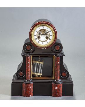 1132-Reloj de sobremesa Napoleón III en mármol negro. jaspe rojo y bronce dorado. Esfera con numeración romana. Con péndulo.