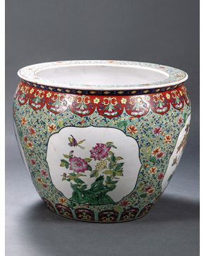 1370-Pecera en porcelana china esmaltada con abigarrada decoración sobre fondo verde agua. con flores en las reservas y peces en su interior. Marcas en la 