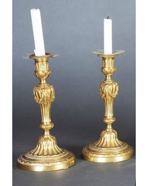 983-Pareja de candeleros en bronce dorado. s. XIX. Decoración de lengüetas y guirnaldas de flores. 