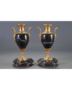 1031-Pareja de jarrones estilo Luis XVI en bronce dorado y mármol negro de Portoro. Asas en forma de cabezas de carnero. Numeradas. 