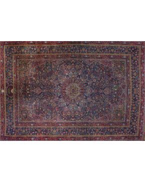 1218-Gran alfombra Sharc antigua en lana con profusa decoración vegetal y floral con rosetón y centro polilobulado sobre campo granate. Colores complemen